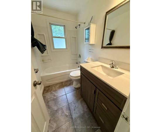 A bathroom with a toilet, sink, and tub.