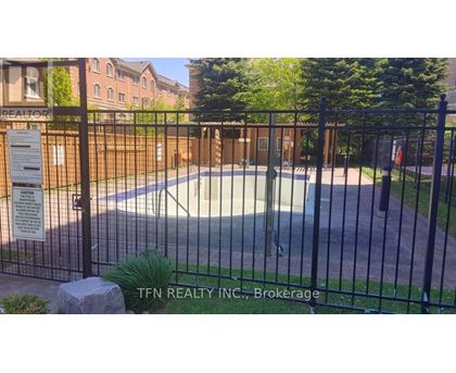 A pool surrounded by a black fence with a sign that says TFN Realty INC., Brokerage.