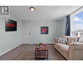 A living room with a couch, a coffee table, and a Netflix sign on the wall.