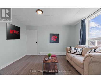 A living room with a couch, a coffee table, and a Netflix sign on the wall.