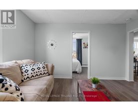 A living room with a couch and a clock on the wall.