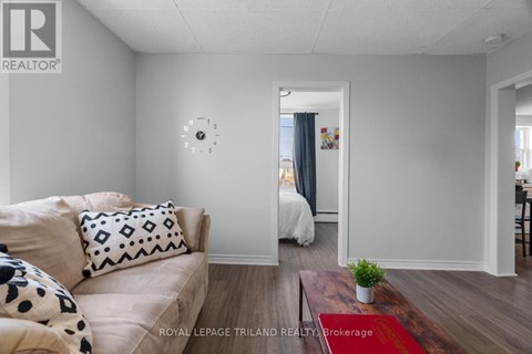 A living room with a couch and a clock on the wall.