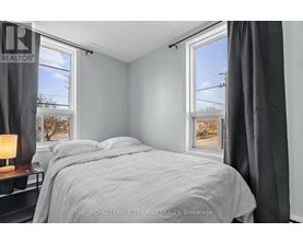 A bedroom with a large bed and a window overlooking a street.