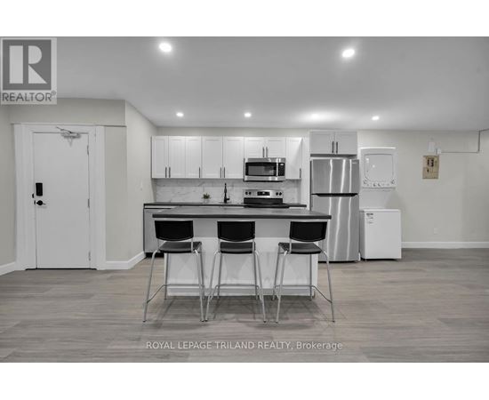 A modern kitchen with white cabinets and a black countertop.