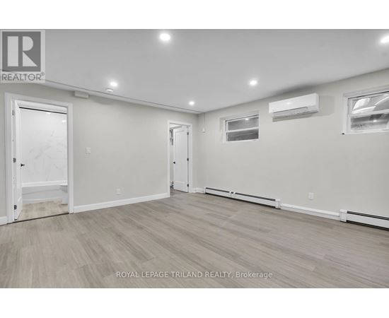 A spacious room with a door on the left and a window on the right.