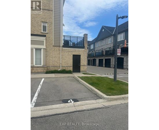 A parking lot in front of a building with a no parking sign.