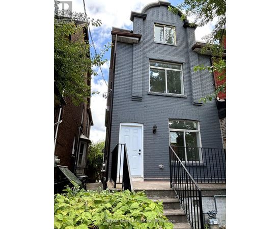 A grey house with a white door and windows.