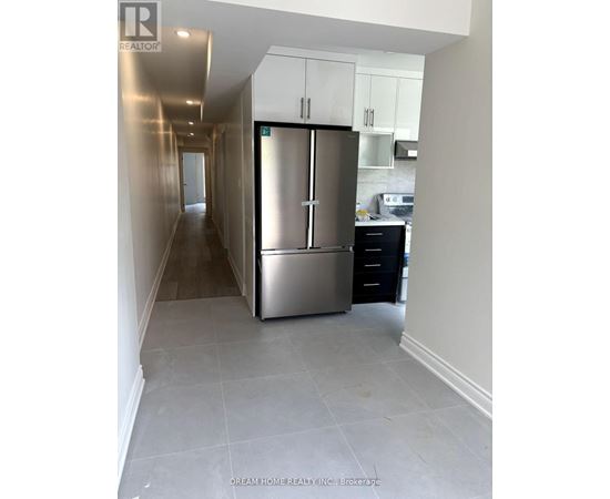A kitchen area with a refrigerator and a stove.