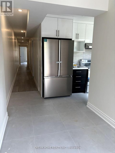 A kitchen area with a refrigerator and a stove.