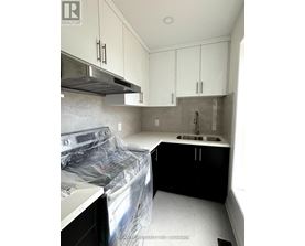 A kitchen under renovation with white cabinets and a sink.