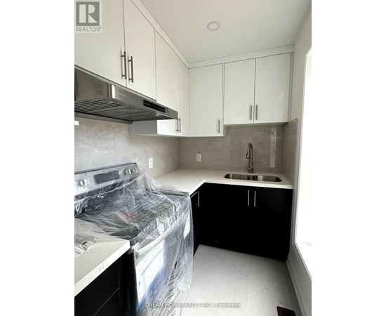 A kitchen under renovation with white cabinets and a sink.