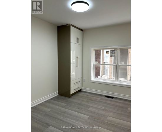 A room with a large window and a wooden floor.
