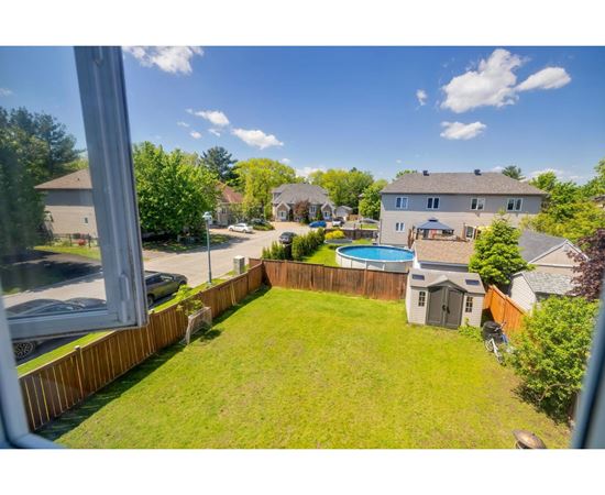 A backyard with a pool and a deck.