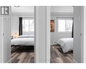A bedroom with two beds and a painting on the wall.
