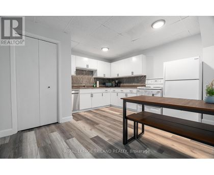 A kitchen with white cabinets and a wooden bench.