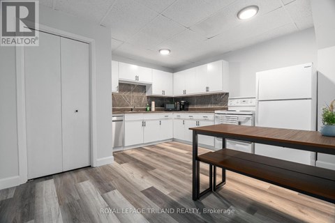 A kitchen with white cabinets and a wooden bench.