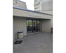 The clubhouse has a glass door and a trash can outside.