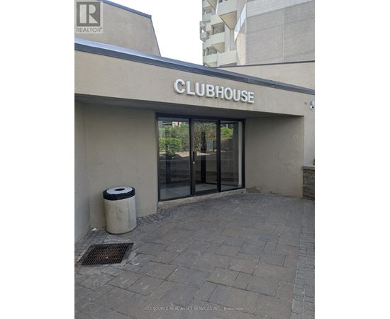 The clubhouse has a glass door and a trash can outside.