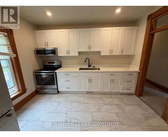 A kitchen with white cabinets and a tiled floor.