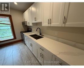 A kitchen with white cabinets and a marble countertop.