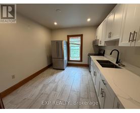 A kitchen with white cabinets and a tile floor.