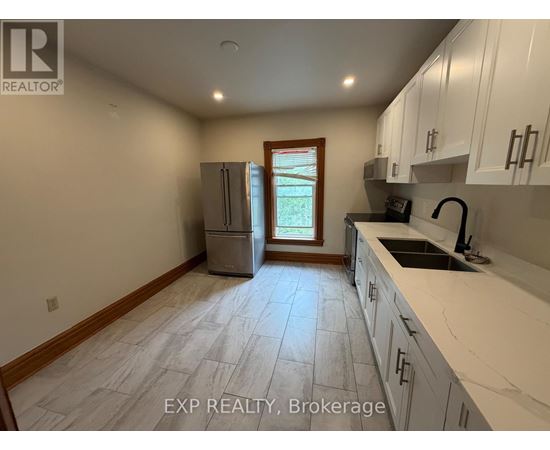 A kitchen with white cabinets and a tile floor.