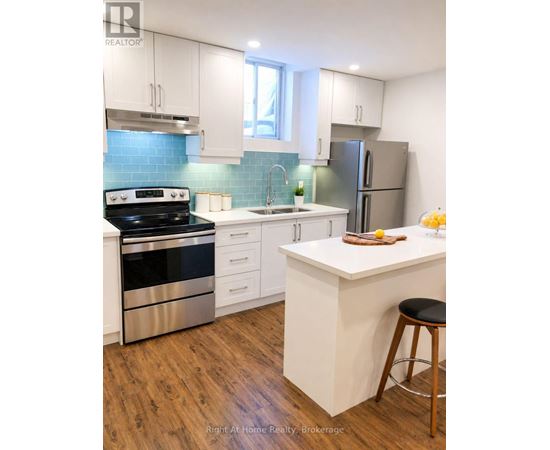 A kitchen with white cabinets and a wooden island.