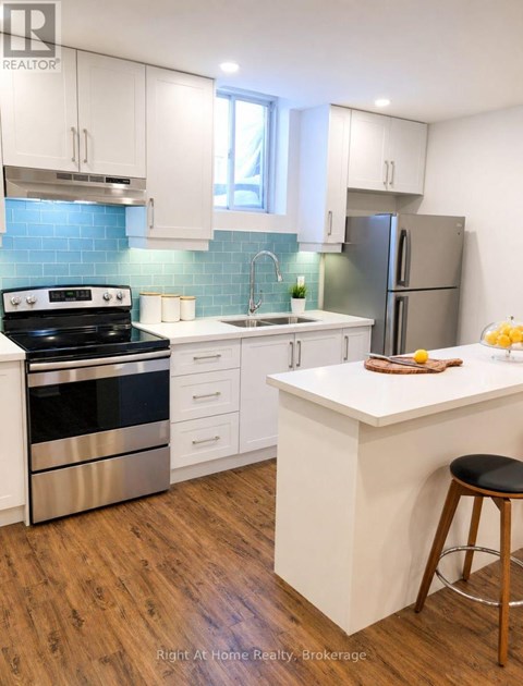 A kitchen with white cabinets and a wooden island.