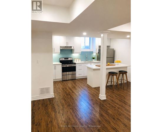 A kitchen with white cabinets and a wooden floor.