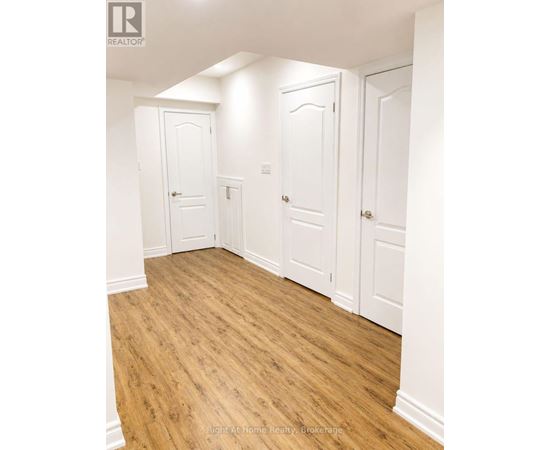A room with white doors and wooden floors.