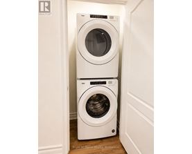 Two white front loading washing machines in a small laundry room.