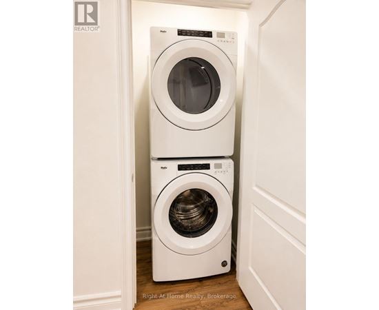 Two white front loading washing machines in a small laundry room.