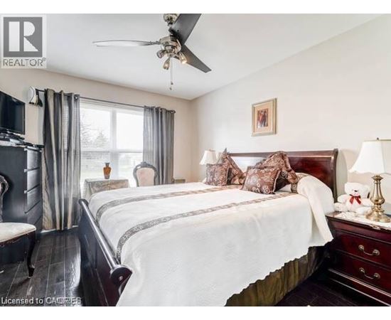 A bedroom with a large bed and a ceiling fan.