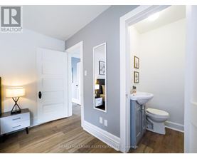 A bathroom with a toilet, sink, and mirror.