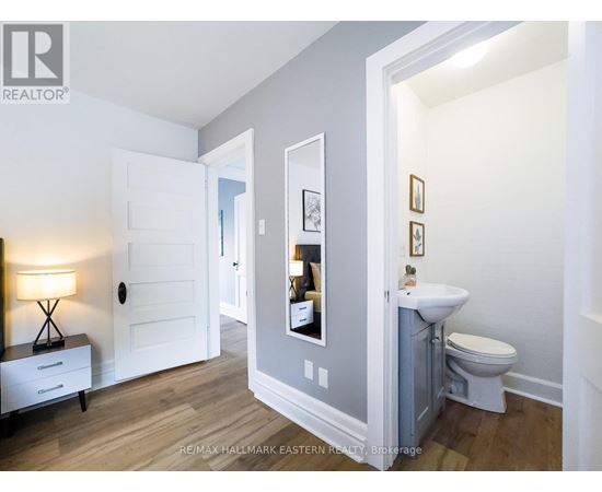 A bathroom with a toilet, sink, and mirror.