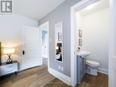 A bathroom with a toilet, sink, and mirror.