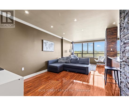 A living room with a couch and a large window.