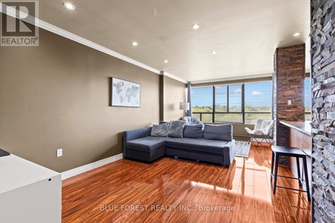 A living room with a couch and a large window.