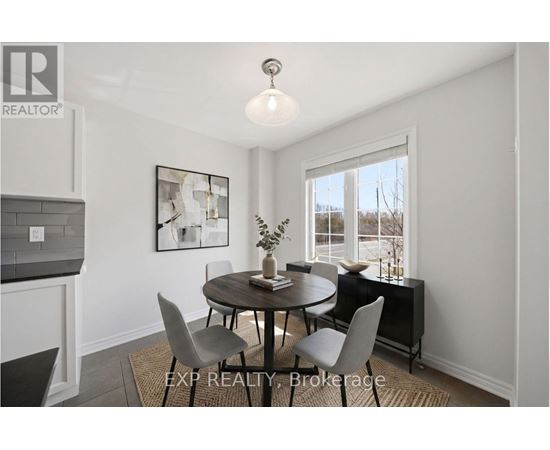 A dining room with a round table and chairs.