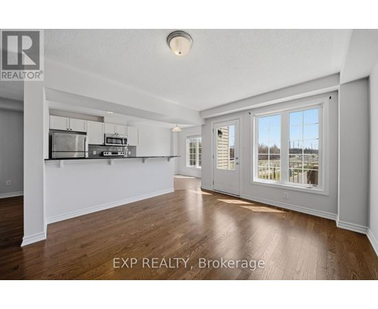 A spacious room with wooden flooring and white walls.