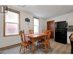 A dining room with a wooden table and chairs.