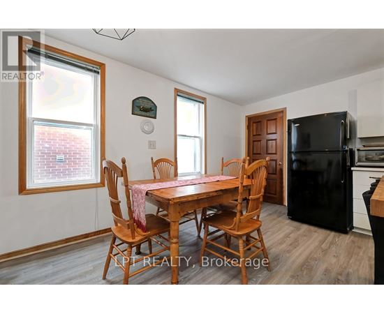 A dining room with a wooden table and chairs.