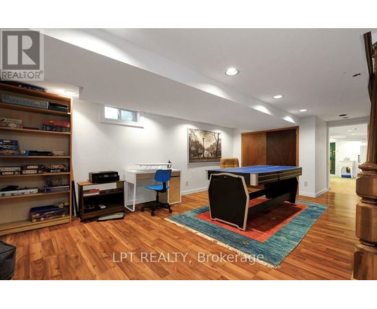 A room with a pool table and a bookshelf.