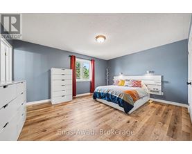 A bedroom with a bed, dresser, and window.
