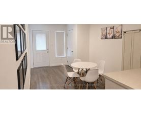 A dining room with a white table and chairs.