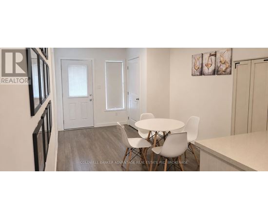A dining room with a white table and chairs.
