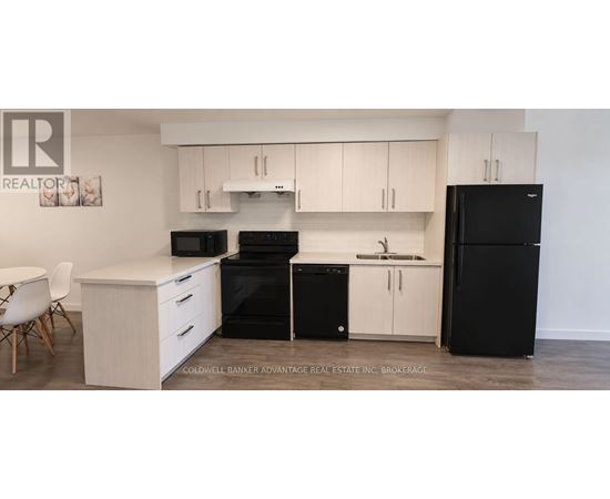 A kitchen with black appliances and white cabinets.