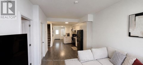 A living room with a white couch and a television.