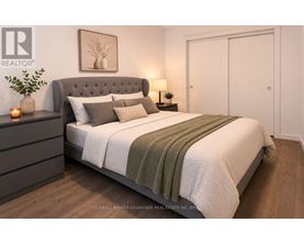 A bedroom with a large bed and a grey headboard.