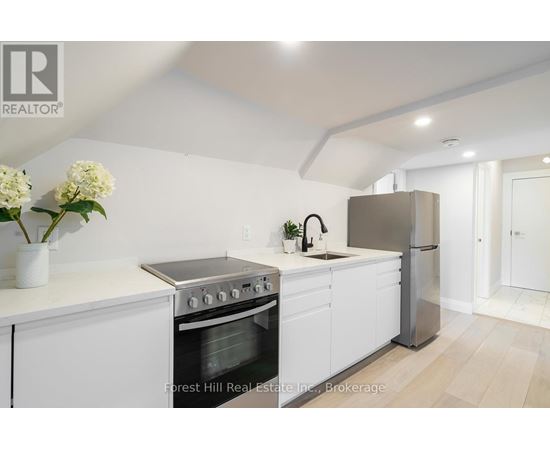 A modern kitchen with white cabinets and stainless steel appliances.